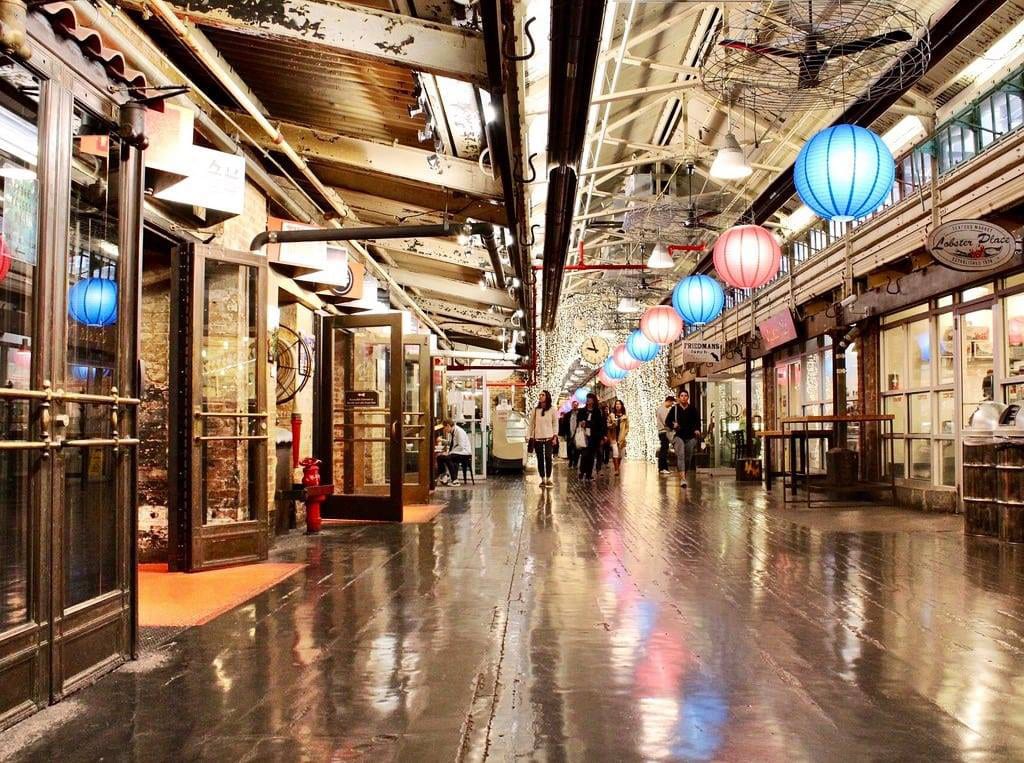 A large indoor shopping mall with many people walking around.