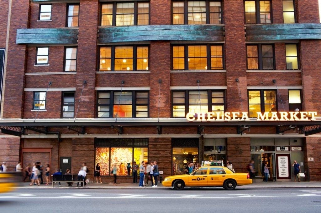 A taxi cab is parked outside of chelsea market.