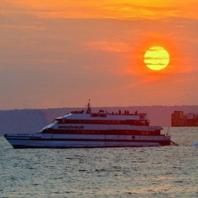 A boat is in the water at sunset.