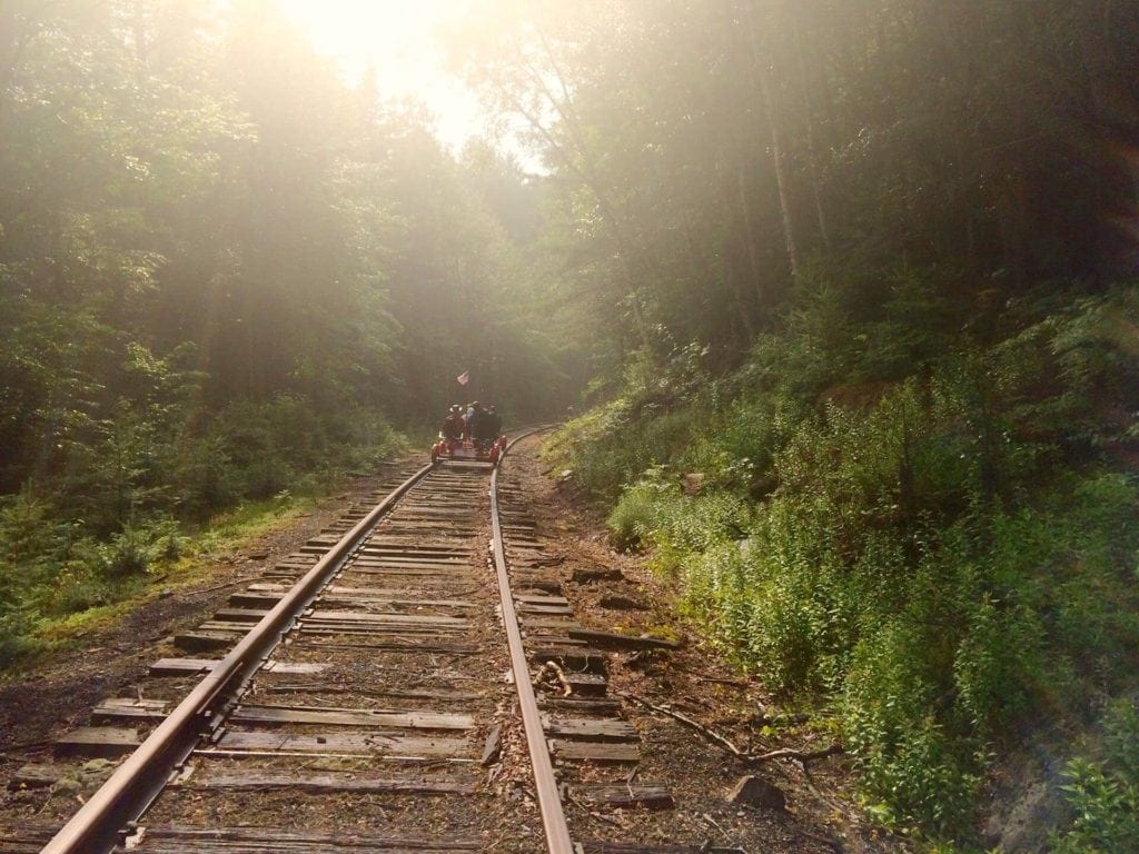 A train track with trees and grass on the side