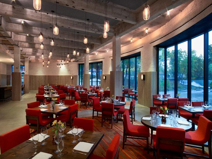 A restaurant with red chairs and tables in it