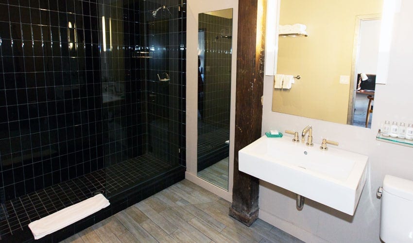 A bathroom with a sink, mirror and shower.