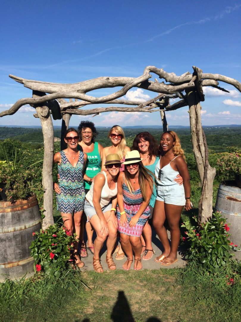 A group of women standing under an arbor.