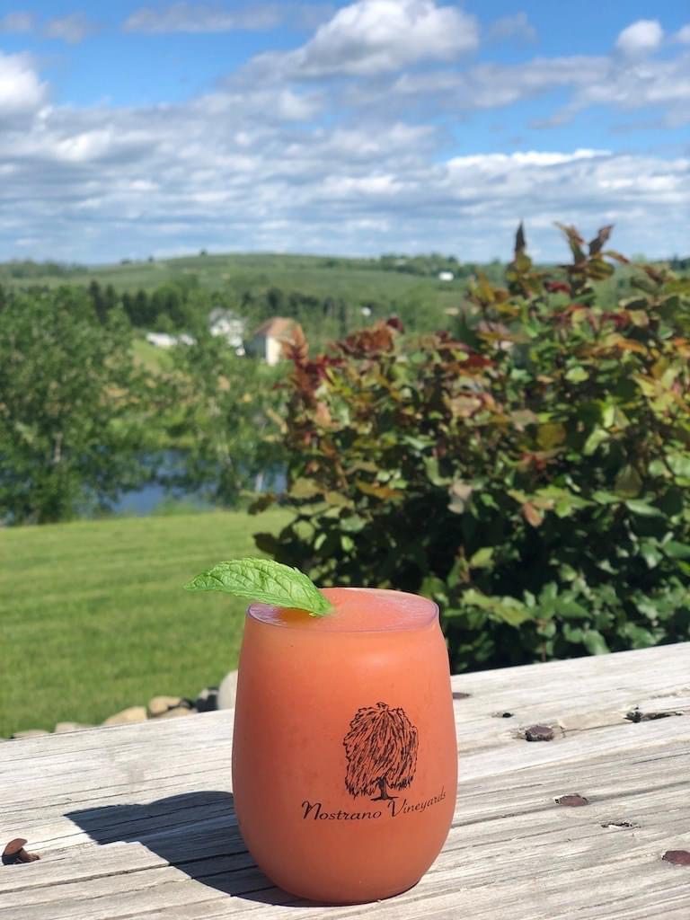 A glass of juice sitting on top of a wooden table.