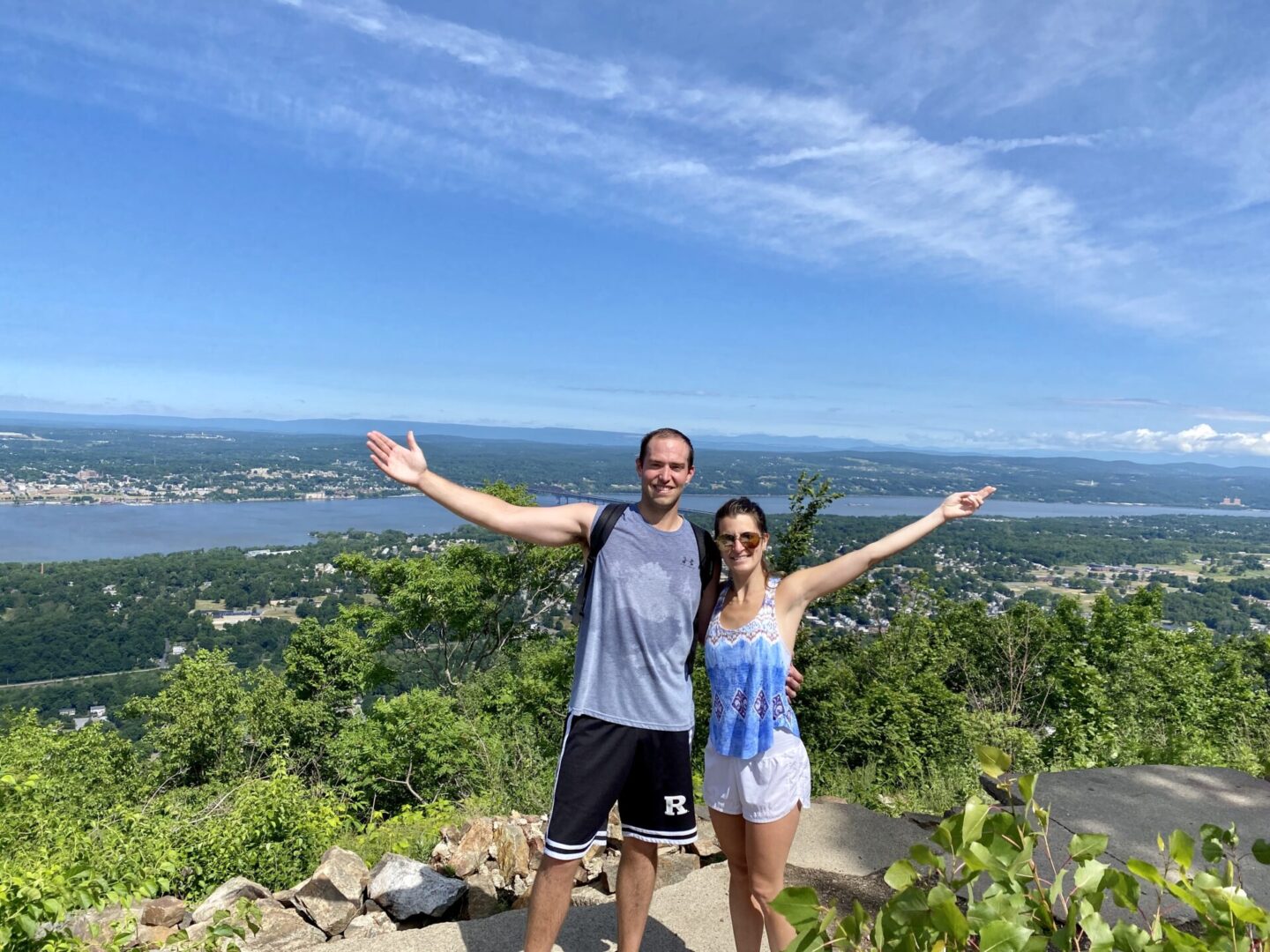 A man and woman standing on top of a hill.