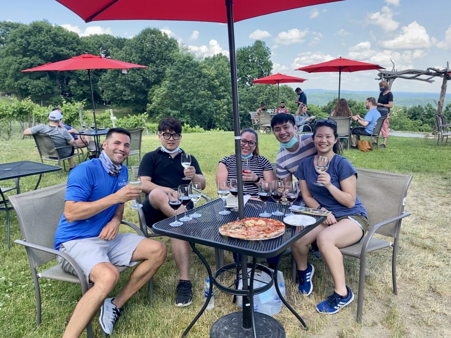 A group of people sitting around a table with pizza.