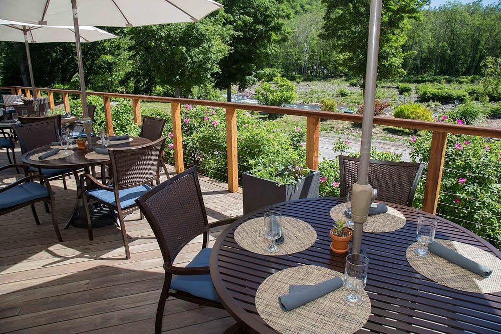 A patio table with chairs and umbrellas on top of it.