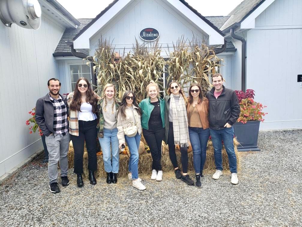 A group of people standing in front of a corn stalk.