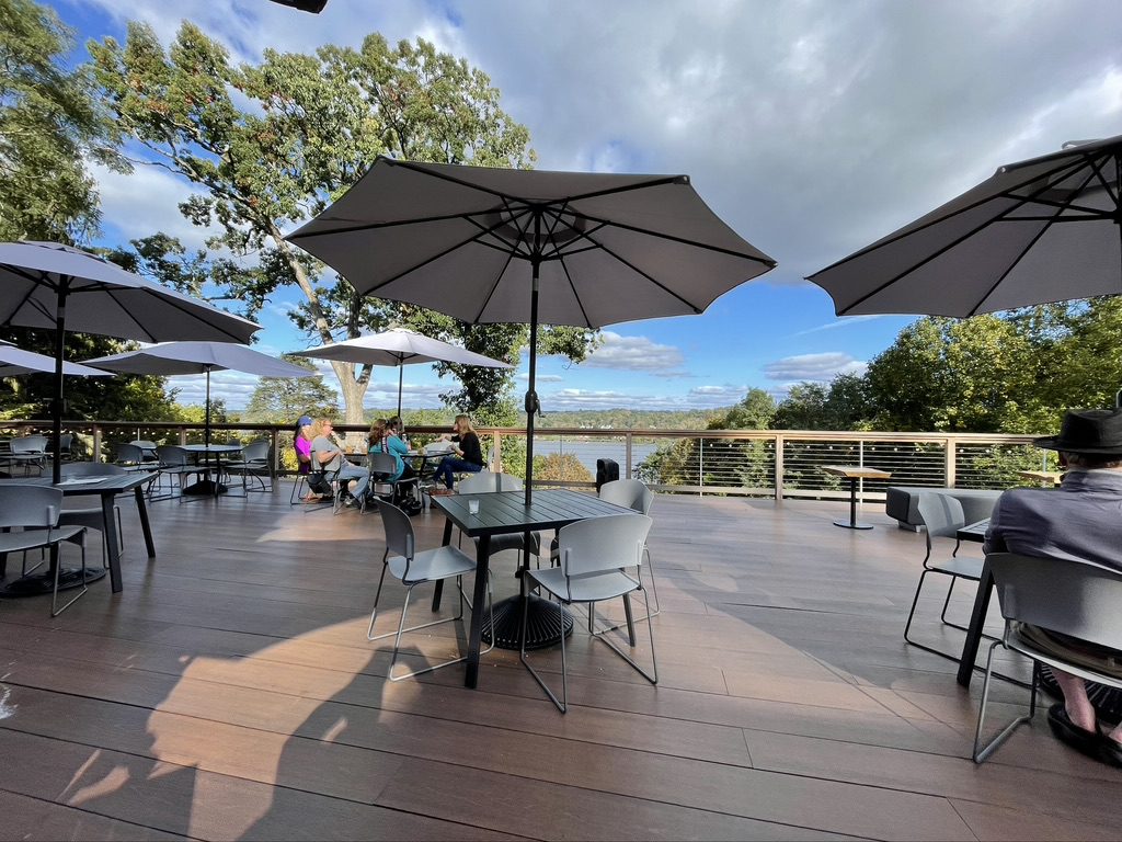 A group of people sitting at tables under umbrellas.