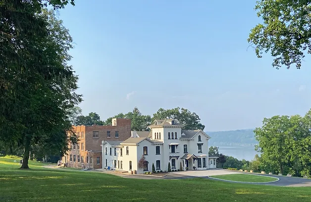 A large white building sitting on top of a green field.