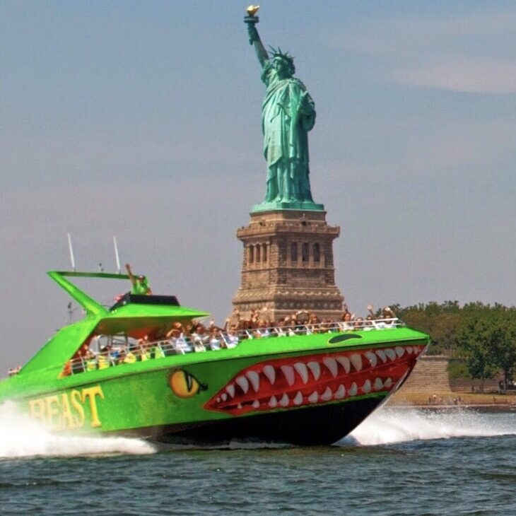 The Beast Speed Boat, NYC A green boat with a shark mouth on the front of it.